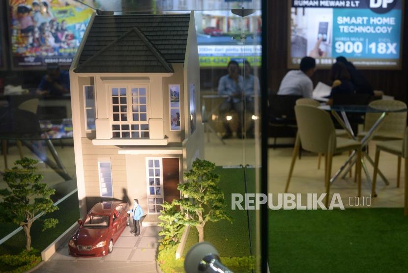 Penjaga stan menjelaskan tentang harga rumah dan fasilitasnya kepada calon konsumen saat pameran perumahan di Jakarta, Ahad (13/5).