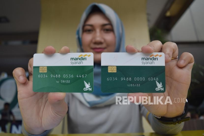 Karyawan Bank Syariah Mandiri menunjukan kartu Mandiri Syariah berlogo Gerbang Pembayaran Nasional (GPN) di acara Silaturrahim dan Berbagi Keceriaan (Siaran) Mandiri Syriah, di Jakarta,Ahad (28/10).