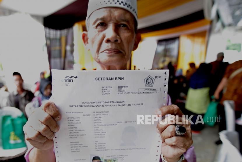 Calon jamaah haji menunjukkan bukti pelunasan Biaya Penyelenggaraan Ibadah Haji (BPIH) di Kantor Cabang Mandiri Syariah Area Bekasi, Jawa Barat, Selasa (19/3/2019).(Republika/Edwin Dwi Putranto)