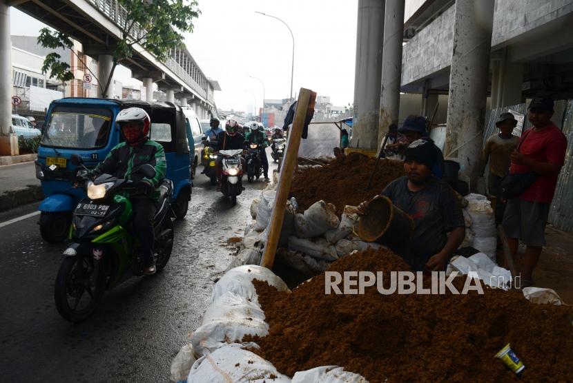 Sejumlah kendaraan melintas di dekat proyek galian kabel serat optik di Jalan Raya Bekasi Barat, Jatinegara, Jakarta, Rabu (27/3).