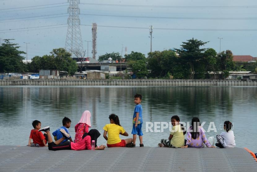 Anak-anak saat bermain di Waduk Cincin, Tanjung Priok, Jakarta Utara, Ahad (13/1).
