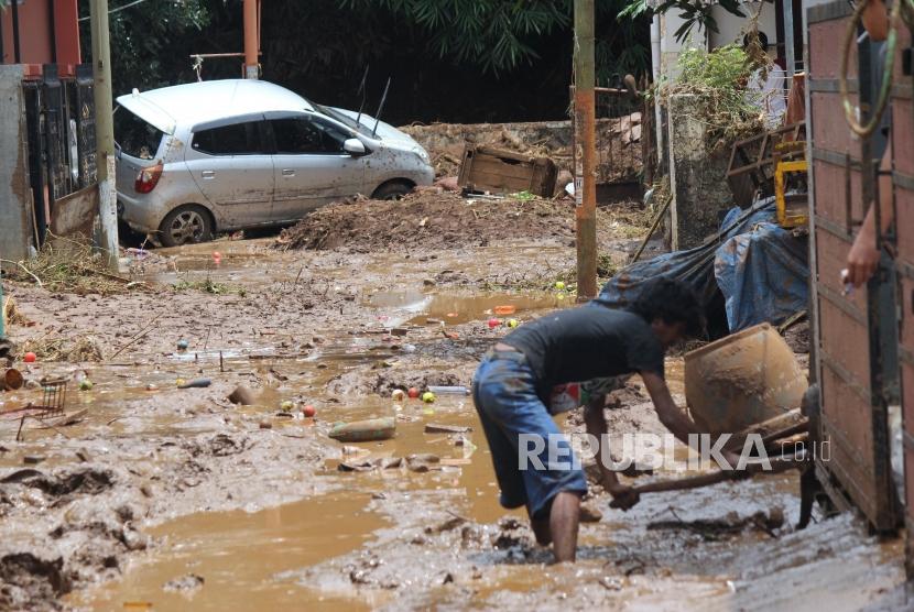 Warga membersihkan lumpur sisa banjir bandang di kawasan perumahan daerah Jatihandap, Kota Bandung, Rabu (21/3).