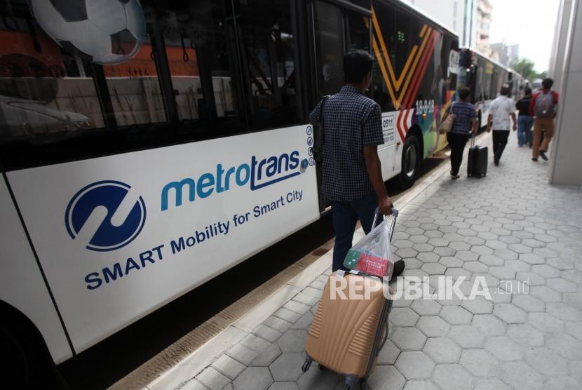 Warga berjalan disamping bus Metrotrans saat uji coba integritas Transjakarta.