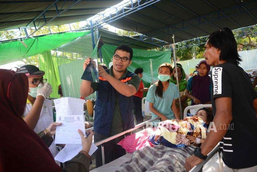 Dokter  memberikan keterangan kepada  keluarga korban terkait kondisi korban  di rumah sakit lapangan di Rumah Sakit Tanjung, Lombok Utara, Nusa Tenggara Barat, Rabu (8/8).