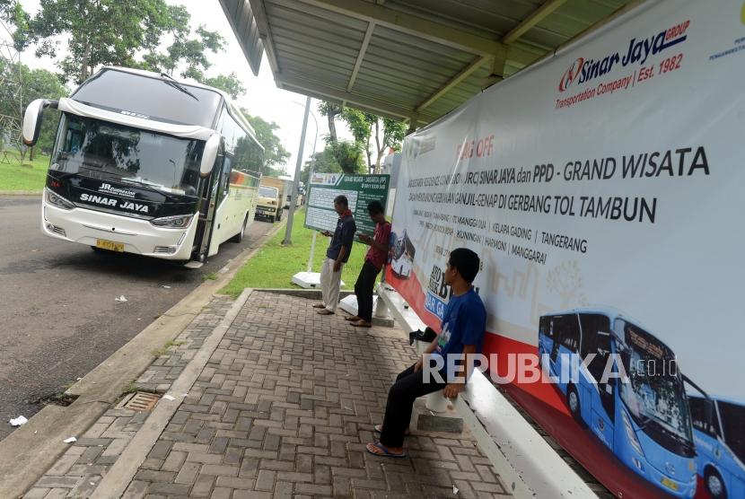 Sejumlah warga menunggu keberangkatan bus layanan Jabodetabek Residence Connexion (JRC) imbas dari penerapan sistem ganjil-genap di Gerbang Tol Tambun, Bekasi, Jawa Barat, Selasa (4/12).
