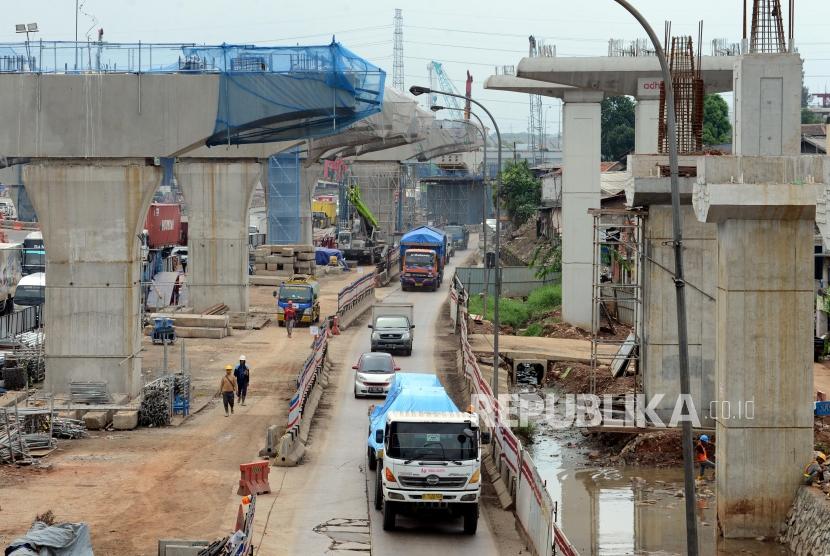 Sejumlah kendaraan melintas di area proyek pembangunan Tol Layang Jakarta-Cikampek II dan Jalur kereta api ringan atau Light Rail Transit (LRT) Jabodebek di ruas Tol Jakarta Cikampek, Bekasi, Jawa Barat, Selasa (4/12).