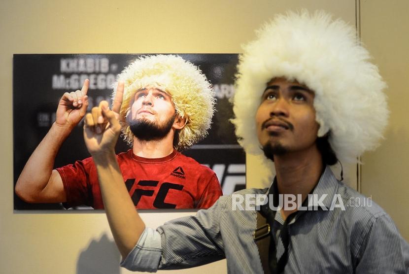 Pameran Foto Islam Rusia. Pengunjung menirukan gaya pada foto atlet bela diri Khabib Nurmagomedov yang dipajang saat pameran foto tradisi umat Islam di Rusia di Musium Bayt Al-Quran TMII, Jakarta, Selasa (26/2).