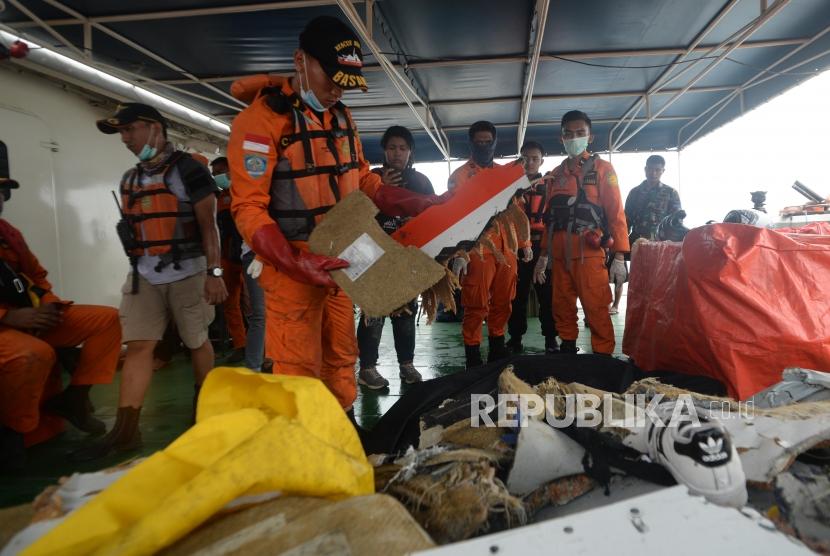 Anggota Basarnas  memeriksa serpihan  pesawat jatuh Lion Air JT610 di perairan Karawang, Jawa Barat. Selasa (30/10).