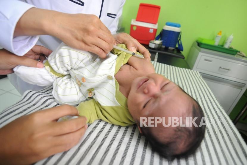 Balita menangis saat disuntik imunisasi difteri di Puskemas Cimanggis, Depok, Jawa Barat, Rabu (6/12).