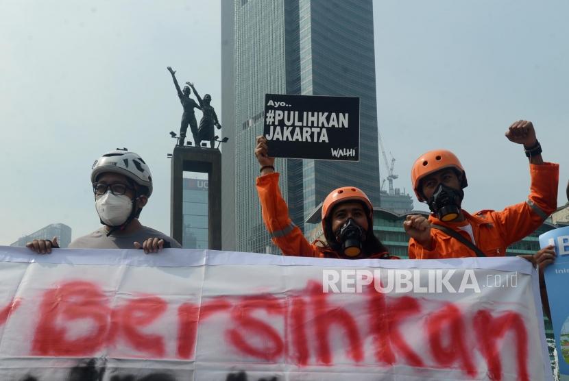 Sejumlah aktivis Gerakan Inisiatif Bersihkan Udara Koalisi Semesta (Ibu Kota) mengendarai sepeda mengggunakan masker saat aksi di Bundaran HI, Jakarta, Rabu (5/12).