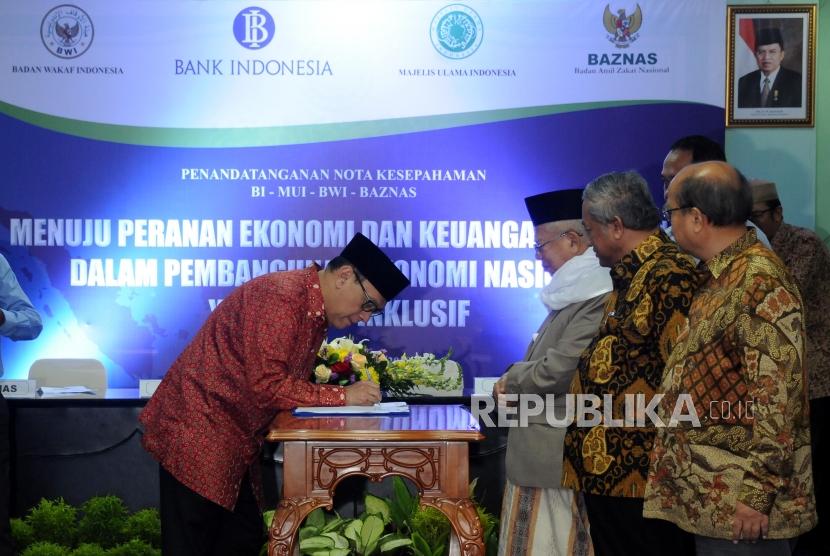 Gubernur Bank Indonesia (BI) Agus Martowardojo bersama Ketua Umum MUI KH. Ma'ruf Amin, Ketua Badan Wakaf Indonesia (BWI) Mohammad Nuh dan Ketua Badan Amil Zakat Nasional (Baznas) Bambang Sudibyo (dari kiri) saat penandatanganan nota kesepahaman di Kantor MUI, Jakarta, Rabu (24/1).