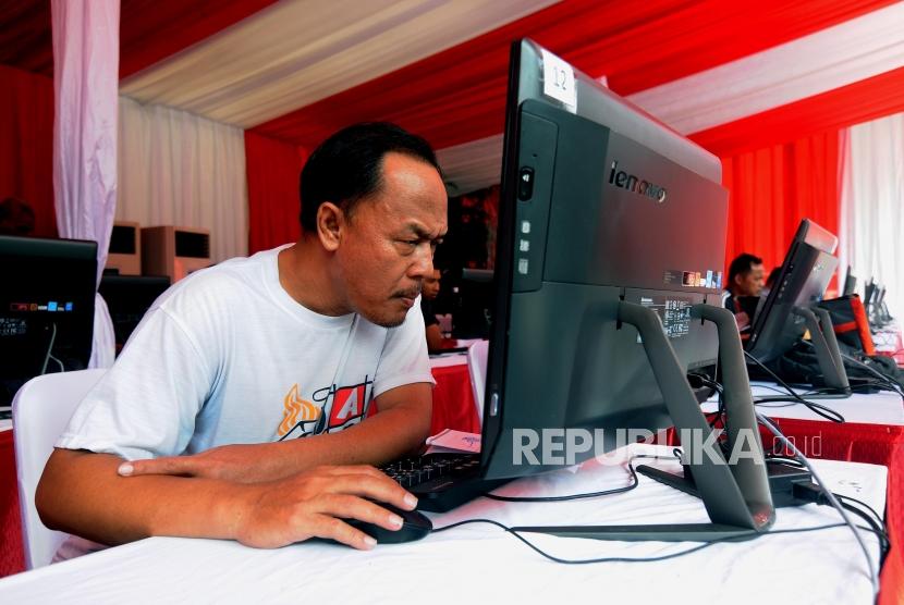 Warga melakukan ujian teori pada kegiatan pembuatan SIM A Umum kolektif untuk pengemudi angkutan taksi online dan konvensional di kawasan Gelora Bung Karno (GBK), Senayan, Jakarta, Ahad (25/2).