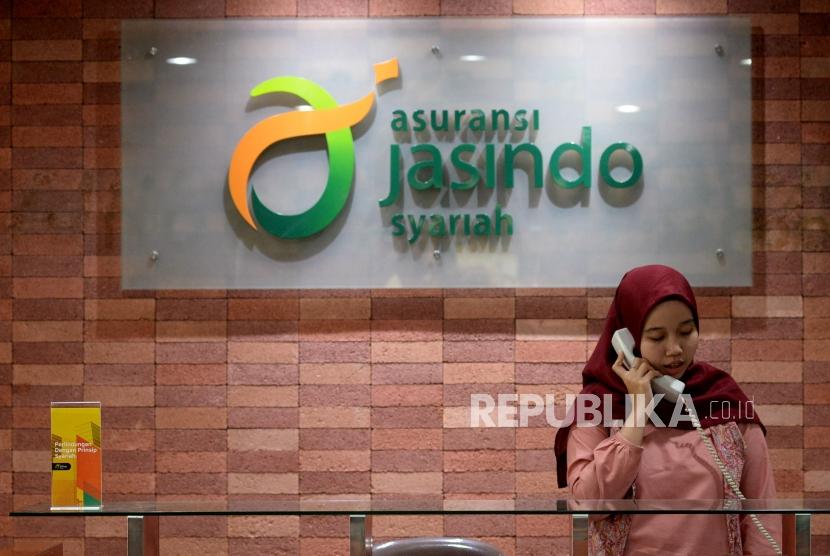Karyawan memberikan informasi produk kepada calon peserta di kantor Asuransi Jasindo Syariah, Jakarta, Selasa (16/7).