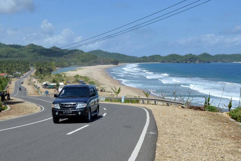 Kendaraan melintas di Jalan Lintas Pantai Selatan di tepi pantai Soge, Ngadirejo, Pacitan, Jatim.