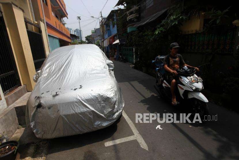 Kendaraan melintas disamping mobil yang terparkir di Jalan Penggalang Raya, Matraman, Jakarta. Dishub DKI akan menindak pemilik kendaraan parkir di jalan karena tak punya garasi.
