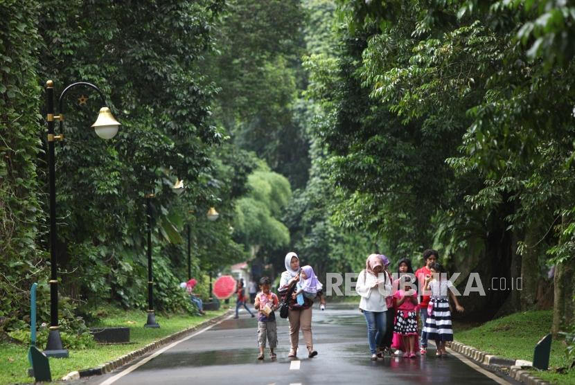 Warga berwisata ke Kebun Raya Bogor, Jawa Barat, Sabtu (23/12).