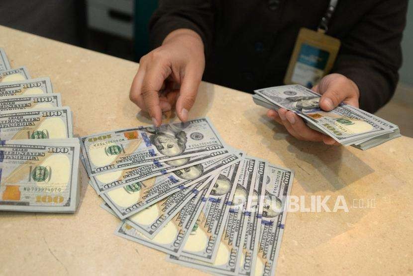 Performa Terburuk di Asia. Petugas menghitung mata uang Dolar AS di jasa penukaran uang BSM, Jakarta, Senin (13/8).