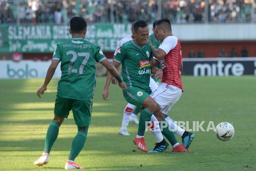 PSS Ditahan Imbang Persipura. Pemain PSS Jajang Sukmara (tengah) berebut bola dengan pemain Persipura pada pertandingan Liga 1 di Stadion Maguwoharjo, Sleman, Yogyakarta, Kamis (19/9/2019).
