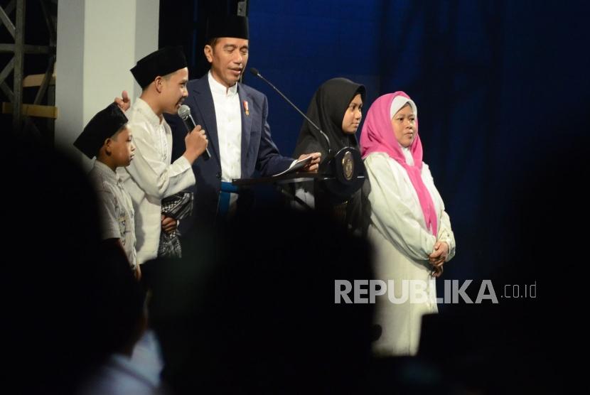Didampingi sejumlah santri, Presiden RI Joko Widodo (Jokowi) berdialog dengan para santri saat menghadiri malam puncak peringatan Hari Santri Nusantara, di Lapangan Gasibu, Kota Bandung, Ahad (21/10).