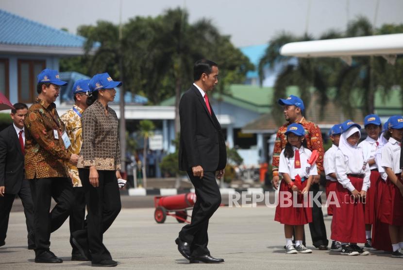 Presiden Joko Widodo (tengah) berjalan untuk menghadiri acara Pemberian Nama Pesawat N219 di Bandara Halim Perdana Kusuma, Jakarta, Jumat (10/11). Jokowi members nama persawat tersebut Nurtanio yang diambil dari nama Laksamana Muda Udara (Anumerta) Nurtanio Pringgoadisuryo, untuk pesawat tersebut.