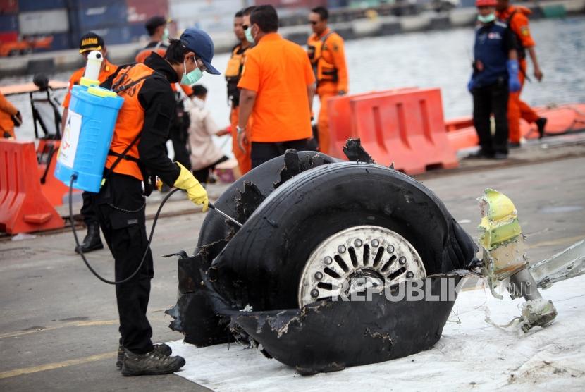 Petugas menyemprotkan disinfektan ke puing-puing pesawat Lion Air JT-610 di Tanjung Priok, Jakarta, Senin (5/11).