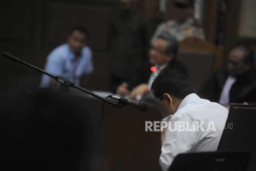 Terdakwa kasus dugaan korupsi KTP elektronik Setya Novanto duduk  tertunduk di ruangan pada sidang perdana  di gedung Pengadilan Tipikor Jakarta, Rabu (13/12).
