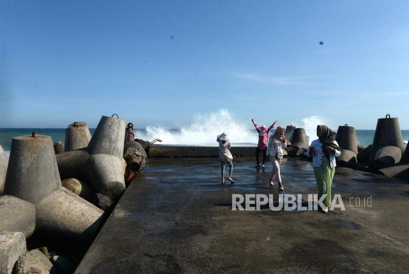 Wisatawan berfoto dengan deburan ombak di Pantai Glagah, Kulonprogo, Yogyakarta, Rabu (12/6/2019).
