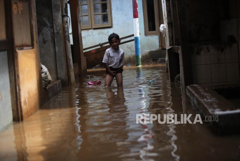 Seorang pelajar Sekolah Dasar berusaha menerobos banjir saat akan pergi ke sekolah di Kebon Pala, Kampung Melayu, Jakarta, Senin (21/5).