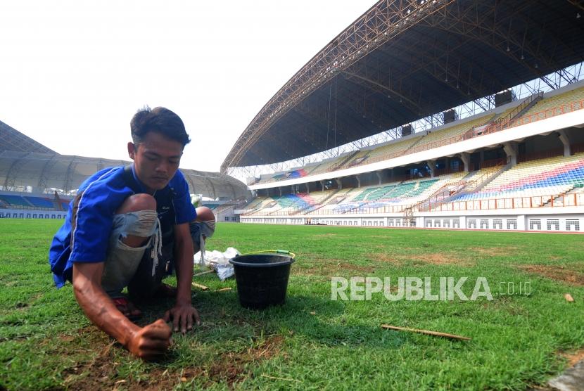Pekerja melakukan perawatan rumput Stadion Wibawa Mukti, Cikarang, Bekasi, Jawa Barat, Jumat (13/7).