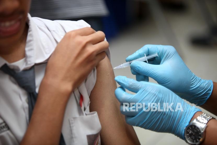 Seorang siswa melakukan imunisasi difteri saat sosialisasi komitmen pelaksaan kegiatan Outbreak Response Immunization (ORI) Difteri di Sekolah SMAN 33 Jakarta, Jalan Kamal Raya, Jakarta Barat, Senin (11/12).