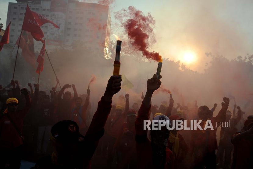 Sejumlah aliansi buruh dari berbagai aliansi  menyalakan flare di  depan Istana Negara pada peringatan Hari Buruh Internasional di Jakarta, Selasa (1/5).