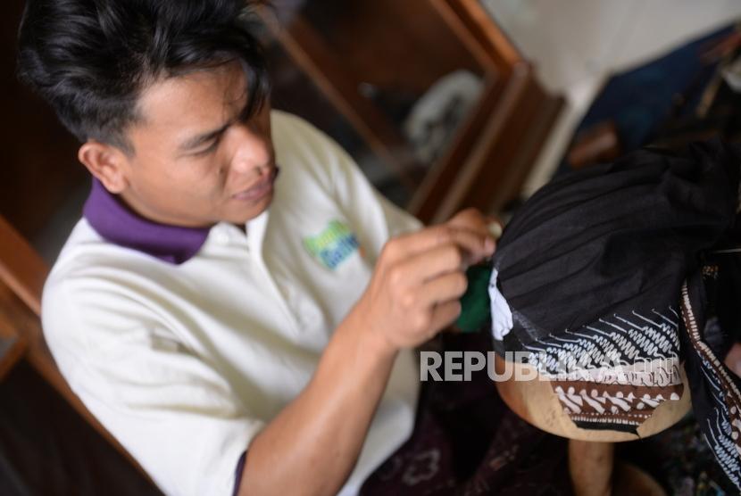 Pekerja menyelesaikan pembuatan blangkon di Yogyakarta, Senin (16/9/2019). Pemerintah masih menargetkan 60 persen dari total penyaluran KUR sepanjang 2020 diberikan kepada sektor produksi.
