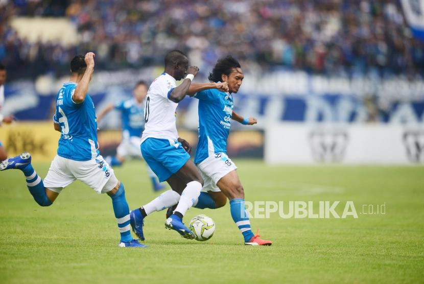 PERSIB-AREMA. Gelandang jangkar Persib Bandung Hariono menahan laju gelandang Arema FC Konate Makan pada pertandingan leg pertama Piala Indonesia babak 16 besar antara Persib Bandung melawan Arema FC di Stadion si Jalak Harupat, Soreang, Senin (18/2).