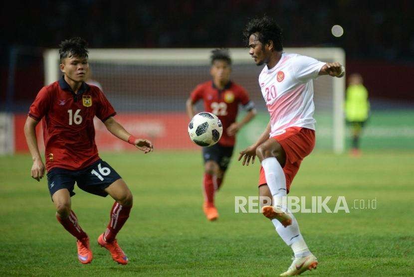 Pesepak bola Indonesia  Ilham Udin Afmaiyn berusaha melewati pemain Laos pada laga penyisihan Grup A cabang sepak bola Asian Games 2018 di Stadion Patriot, Bekasi, Jumat(17/8).