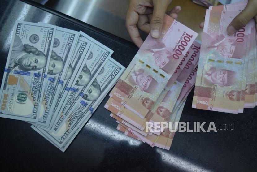 Petugas menghitung mata uang rupiah dan dolar AS di salah satu tempat penukaran uang di Jakarta (ilustrasi).