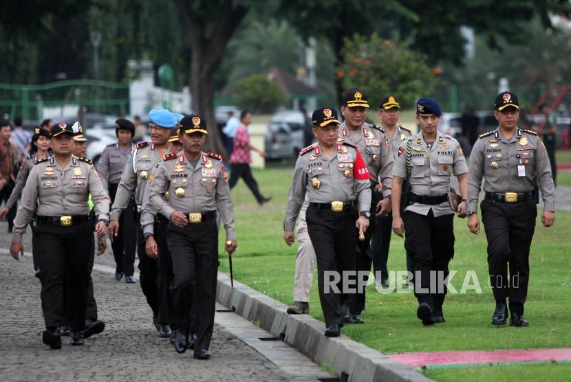 Kapolri Jenderal Tito Karnavian (kanan) bersama Kapolda Metro Jaya Irjen Pol Idham Azis (kiri) berjalan saat Apel Gelar Pasukan Operasi Kepolisian Terpusat Lilin 2017 di Monumen Nasional (Monas), Jakarta, Kamis (21/12).