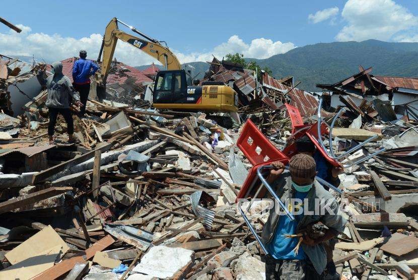 Sejumlah warga menyelamatkan benda berharga yang tertimbun puing-puing bangunan di Perumnas Balaroa, Palu, Sulawesi Tengah, Senin (1/10).