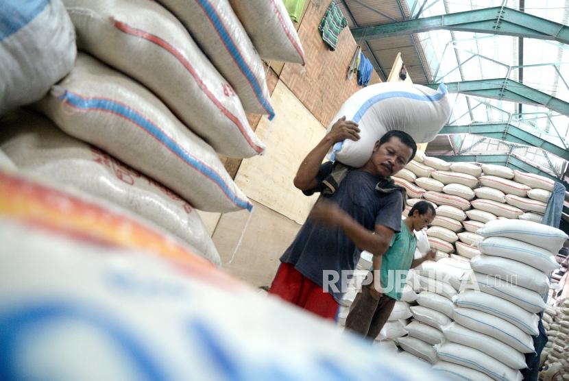 Pekerja memindahkan beras di Pasar Induk Beras Cipinang, Jakarta.