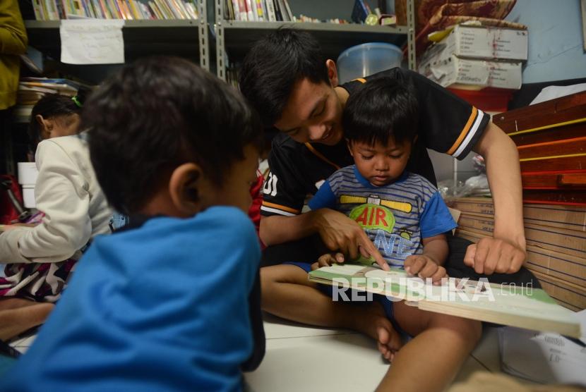 Sejumlah relawan membacakan buku dongeng untuk anak-anak di Sekolah Komunitas Jendela, Manggarai, Jakarta, Ahad (25/11).