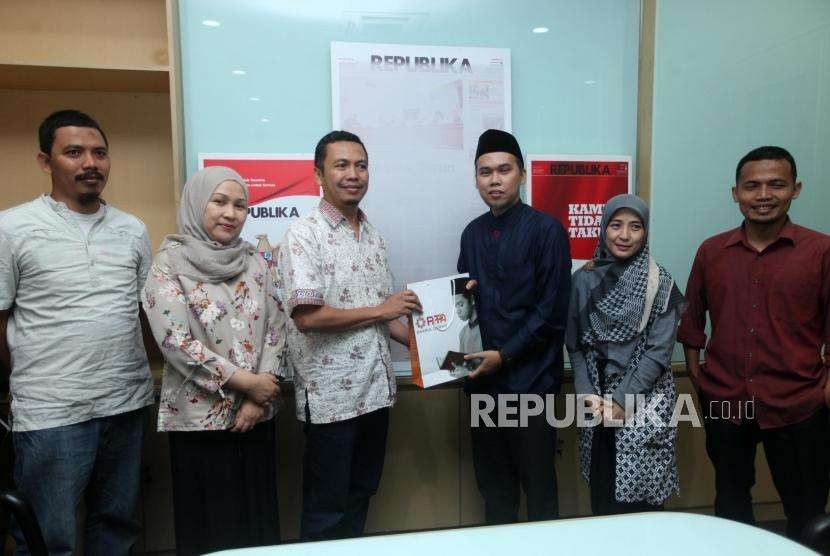 Direktur Eksekutif PPPA Daarul Quran Tarmizi Asshidiq (ketiga kanan) menyerahkan cederamata kepada Redaktur Pelaksana Republika Subroto (ketiga kiri) seusai kunjungan di Kantor Harian Republika, Jalan Warung Buncit, Jakarta, Kamis (6/9).