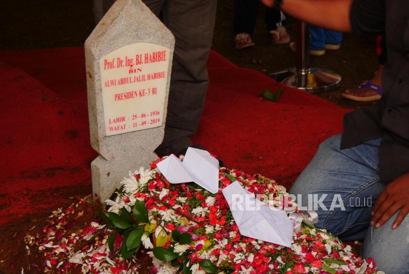 Sebuah pesawat kertas diletakkan di pusara makam presiden ketiga RI BJ Habibie di TMP Kalibata, Jakarta, Kamis (12/9).