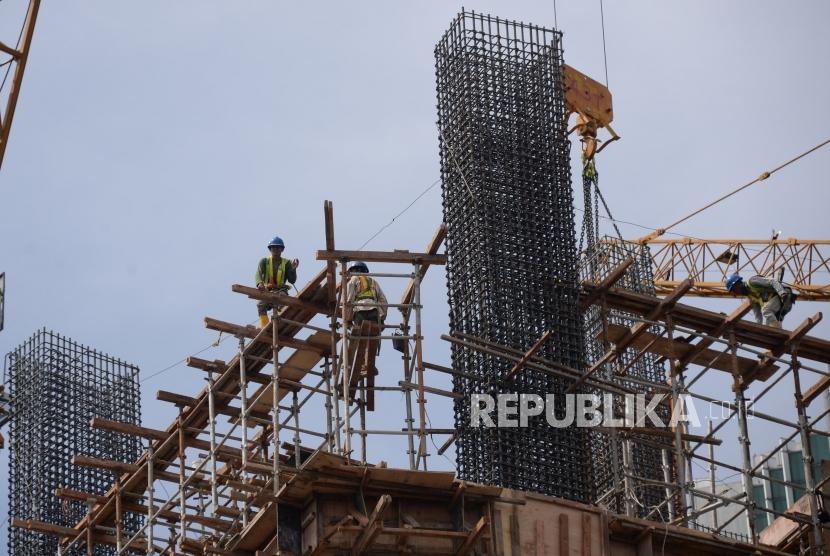 Pekerja beraktivitas dipembangunan gedung bertingakat di Jakarta, Ahad (30/12).