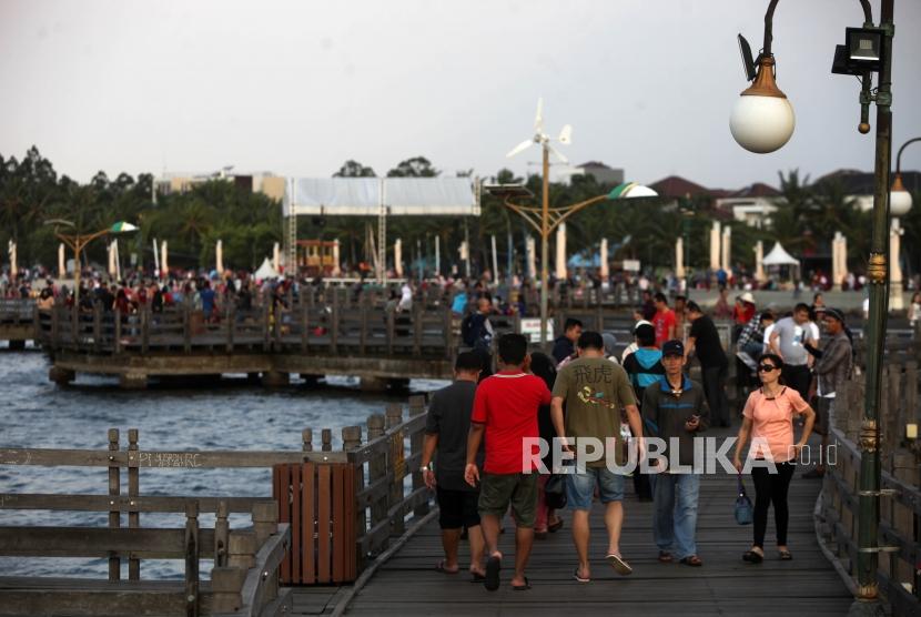 Suasana pengunjung saat liburan di Pantai Ancol, Jakarta, Jumat (30/3).