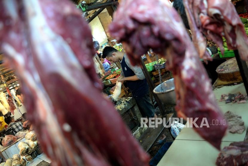 HET Daging Sapi Tidak Efektif. Pedagang memotong daging sapi di Pasar Senen, Jakarta, Jumat (26/1).