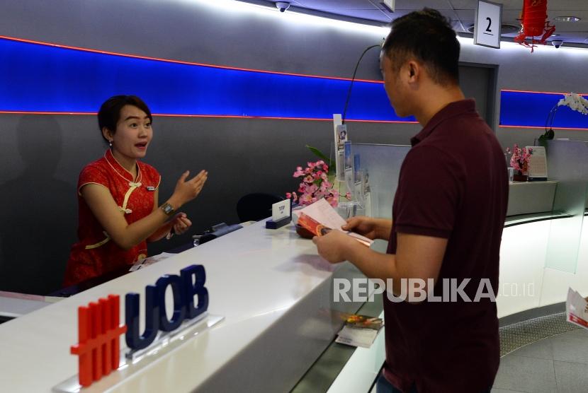 Nasabah melakukan transaksi saat festival Li Chun, satu hari sebelum perayaan imlek di Bank UOB Indonesia, Jakarta, Senin (4/2).