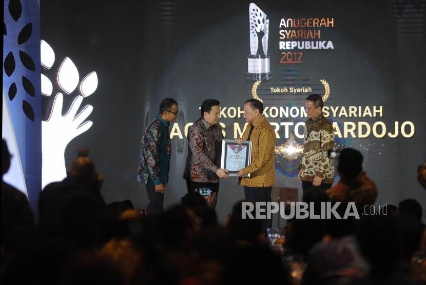  Presiden Direktur Adaro Energy Garibaldi Thohir (kedua kiri) memberikan penghargaan Tokoh Syariah kepada Gubernur BI Agus Martowardojo (kedua kanan) saat Anugerah Syariah Republika (ASR) 2017 di Jakarta, Rabu (6/12) malam. 