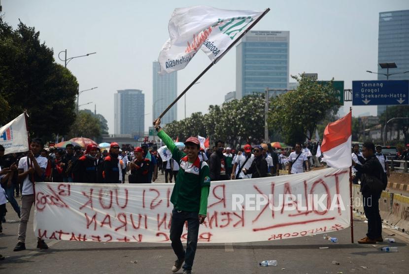 Buruh menggelar aksi di kawasan Senayan, Jakarta, Rabu (2/10).