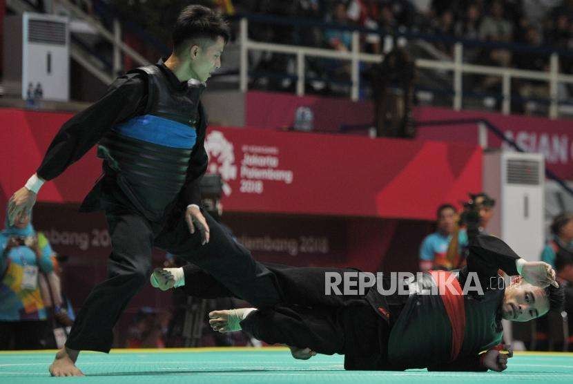 Pesilat Indonesia Abdul Malik (pita merah) bertanding melawan pesilat Vietnam Dinh Tuan Nguyen pada babar penyisihan cabang pencak silat putra kelas B 50-55 kg Asian Games 2018 di Padepokan Pencak Silat TMII, Jakarta, Kamis (23/8).