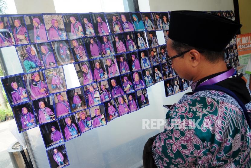 Sejumlah calon jamaah haji melihat foto yang dipajang di Asrama Haji Pondok Gede, Jakarta, Kamis (26/7).