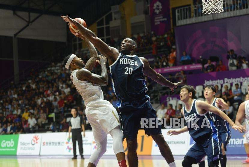 Pemain basket Korea Ricardo Ratliffe menghalangi lemparan bola pemain Indonesia Jamarr Andre Johnson pada babak laga Grup A Asian Games 2018 di Hall Basket Senayan, Jakarta, Selasa (14/8).